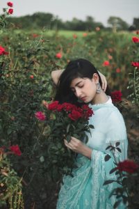 a woman standing in a field of roses